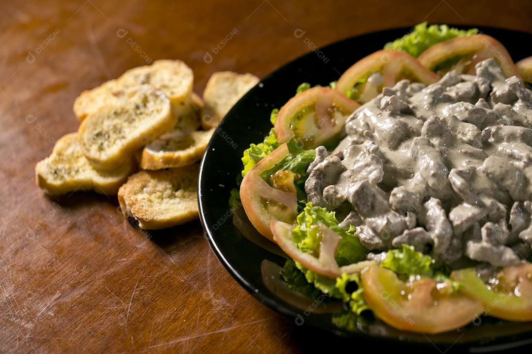 Porção de fígado acebolado sobre a mesa