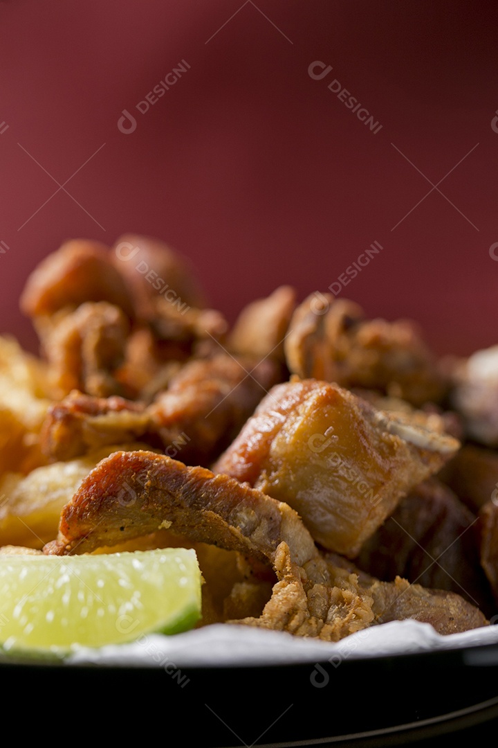 Porção de mandioca frita com costelinha de porco sobre a mesa