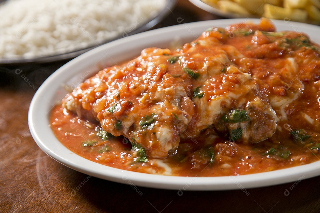 Frango a parmegiana sobre a mesa de madeira