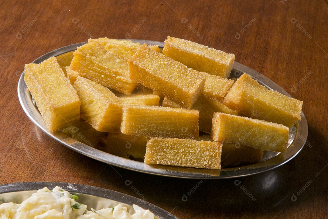Tigela com polenta frita sobre a mesa de madeira