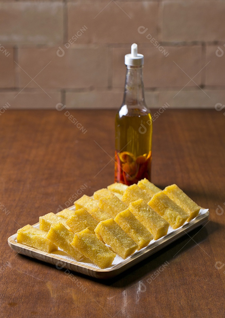 Tigela com polenta frita sobre a mesa de madeira