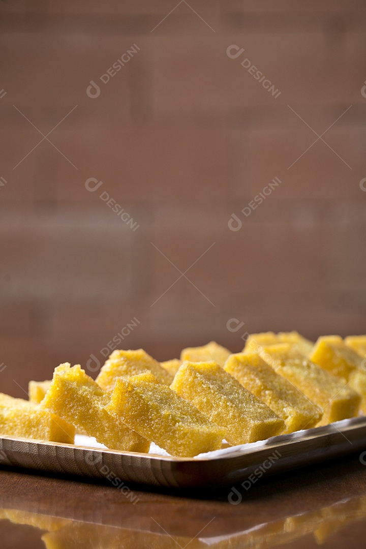 Tigela com polenta frita sobre a mesa de madeira