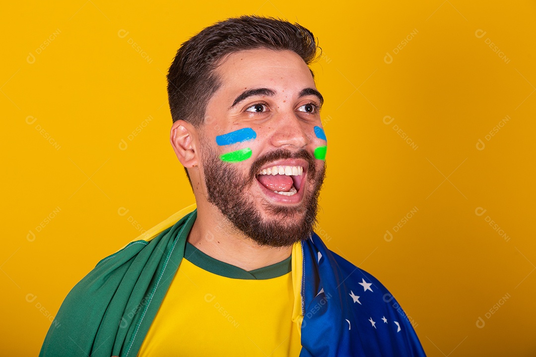 Homem jovem torcedor brasileiros sobre fundo isolado amarelo
