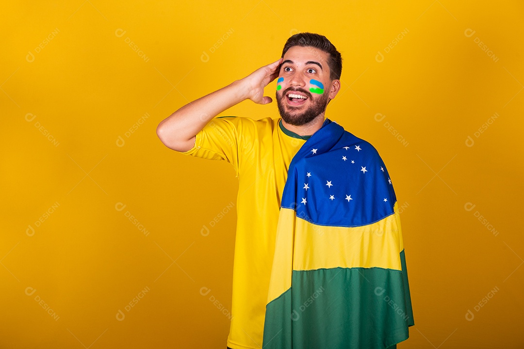 Homem jovem torcedor brasileiros sobre fundo isolado amarelo