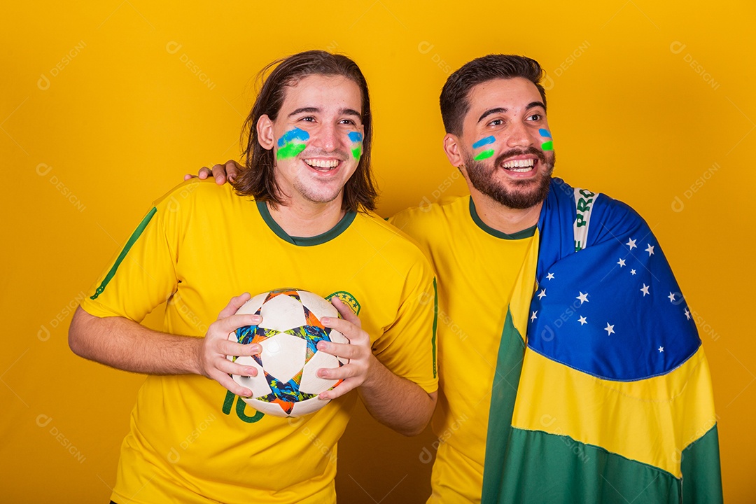 Dois homens jovens torcedores brasileiros sobre fundo isolado amarelo