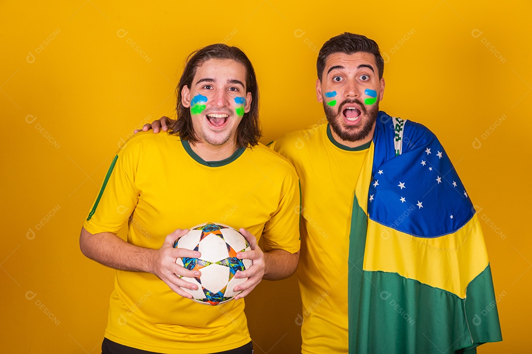 Dois homens jovens torcedores brasileiros sobre fundo isolado amarelo