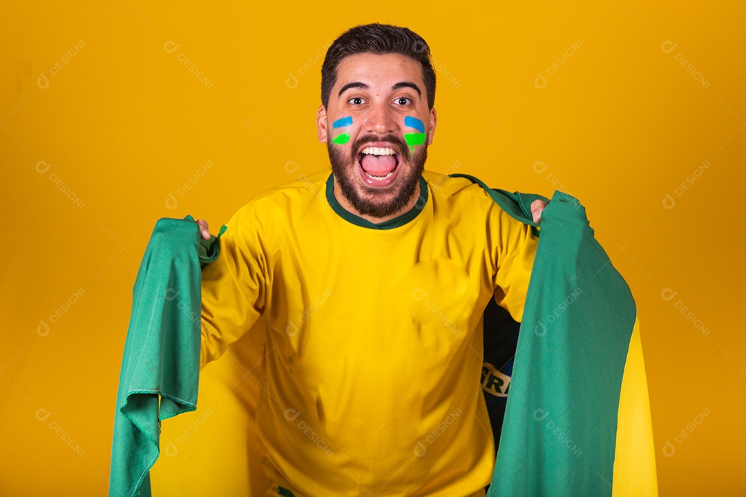 Homem jovem torcedor brasileiros sobre fundo isolado amarelo