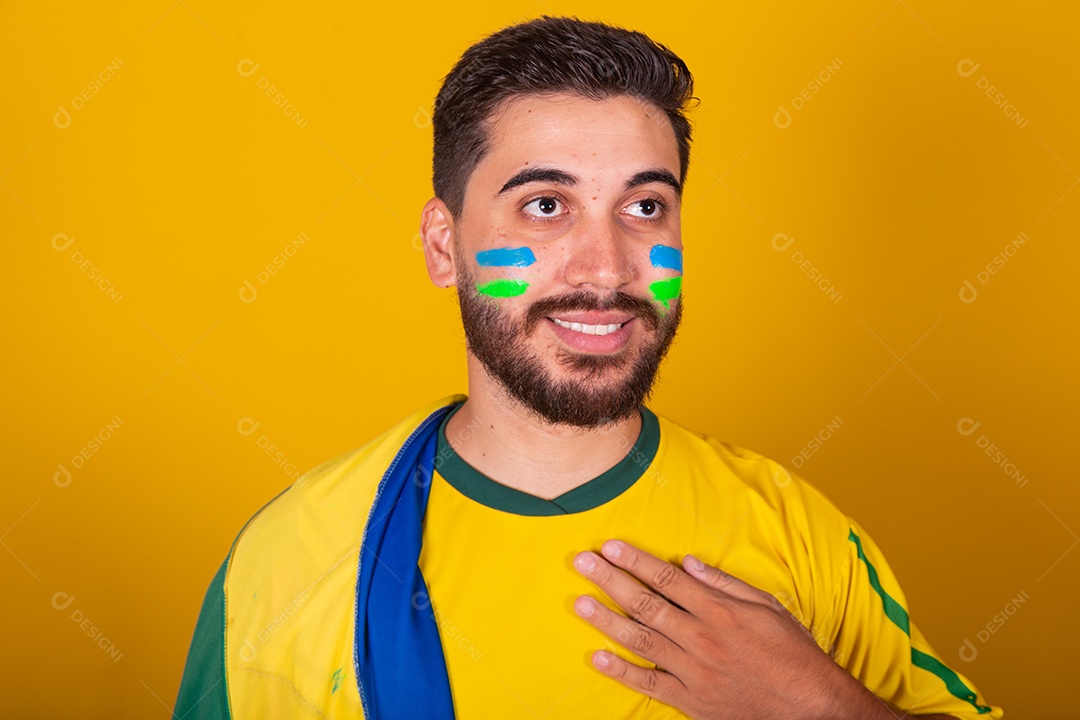 Homem jovem torcedor brasileiros sobre fundo isolado amarelo