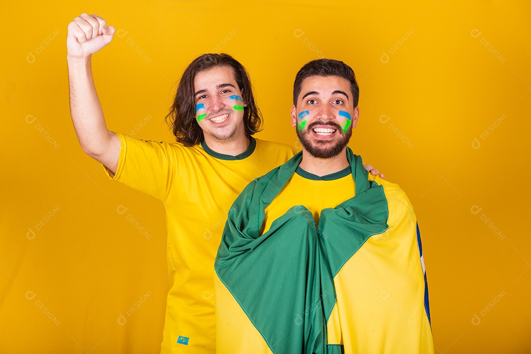 Dois homens jovens torcedores brasileiros sobre fundo isolado amarelo