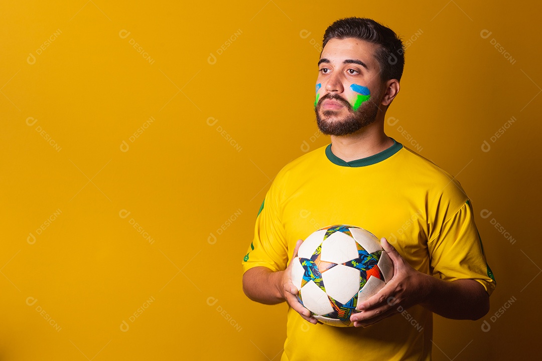 Homem jovem torcedor brasileiros sobre fundo isolado amarelo