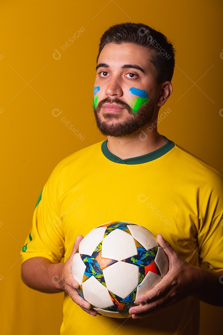Homem jovem torcedor brasileiros sobre fundo isolado amarelo