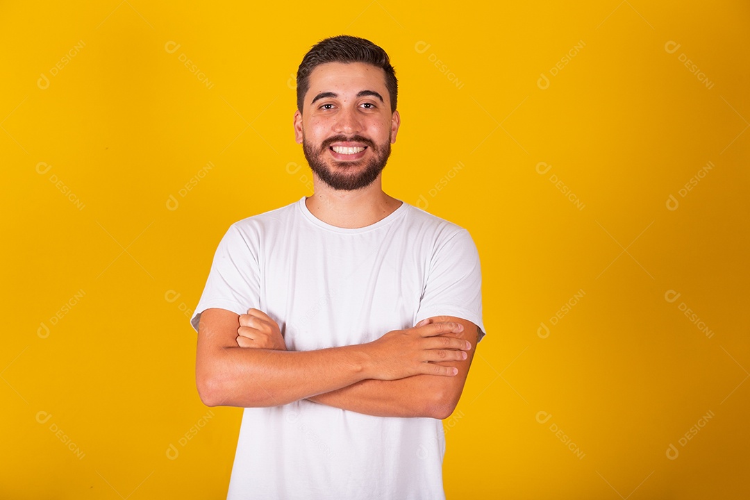 Homem jovem brasileiro sorridente barbudo fundo amarelo