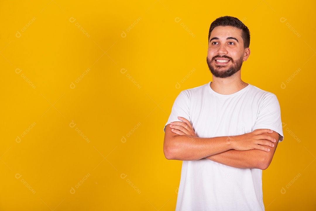 Homem jovem brasileiro sorridente barbudo fundo amarelo