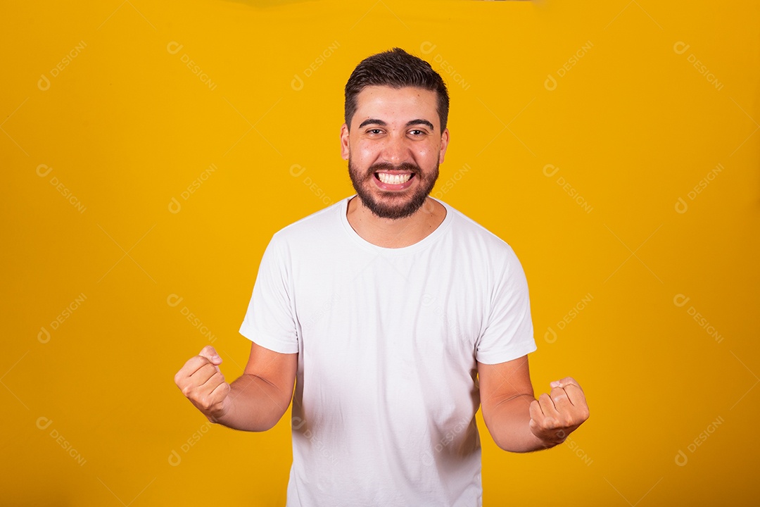 Homem jovem brasileiro sorridente barbudo fundo amarelo