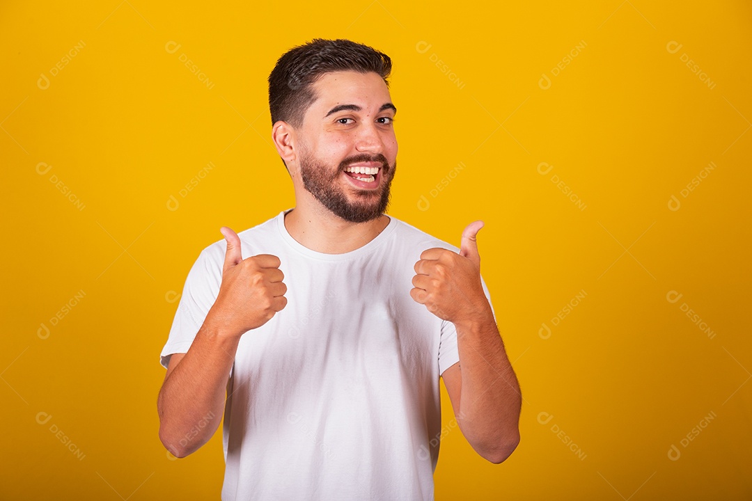 Homem jovem brasileiro sorridente barbudo fundo amarelo