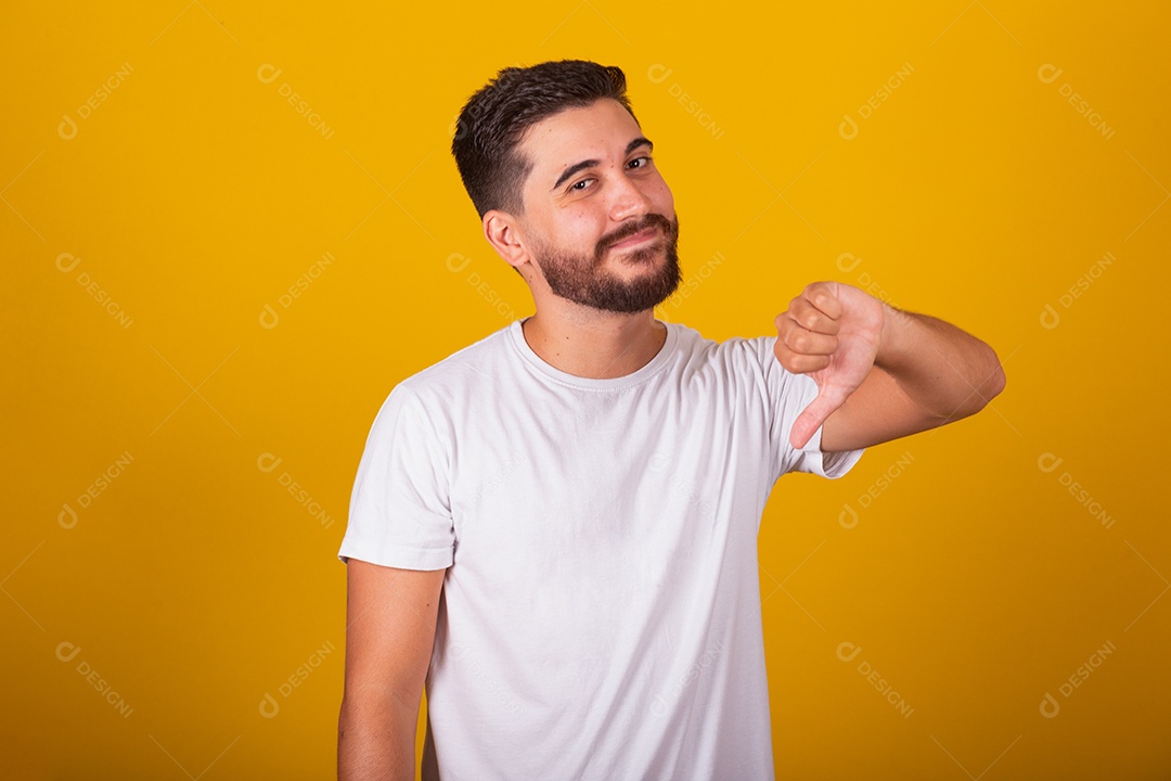 Homem jovem brasileiro sorridente barbudo fundo amarelo