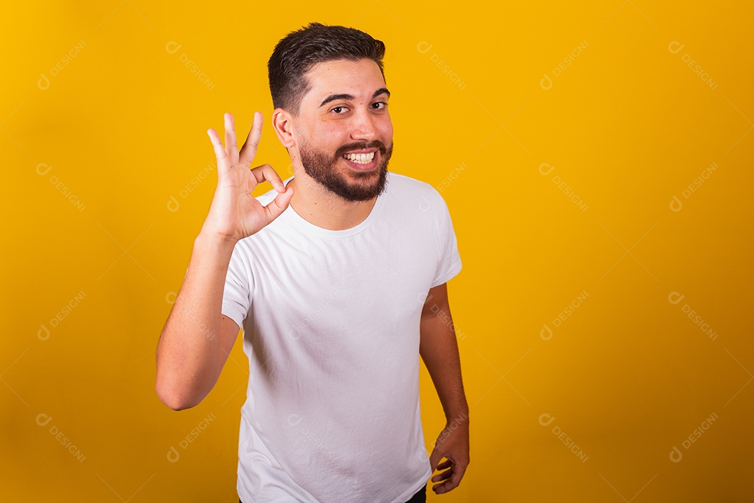 Homem jovem brasileiro sorridente barbudo fundo amarelo