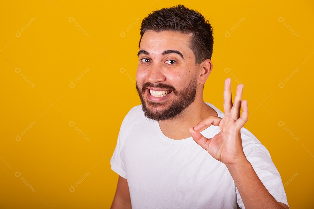 Homem jovem brasileiro sorridente barbudo fundo amarelo