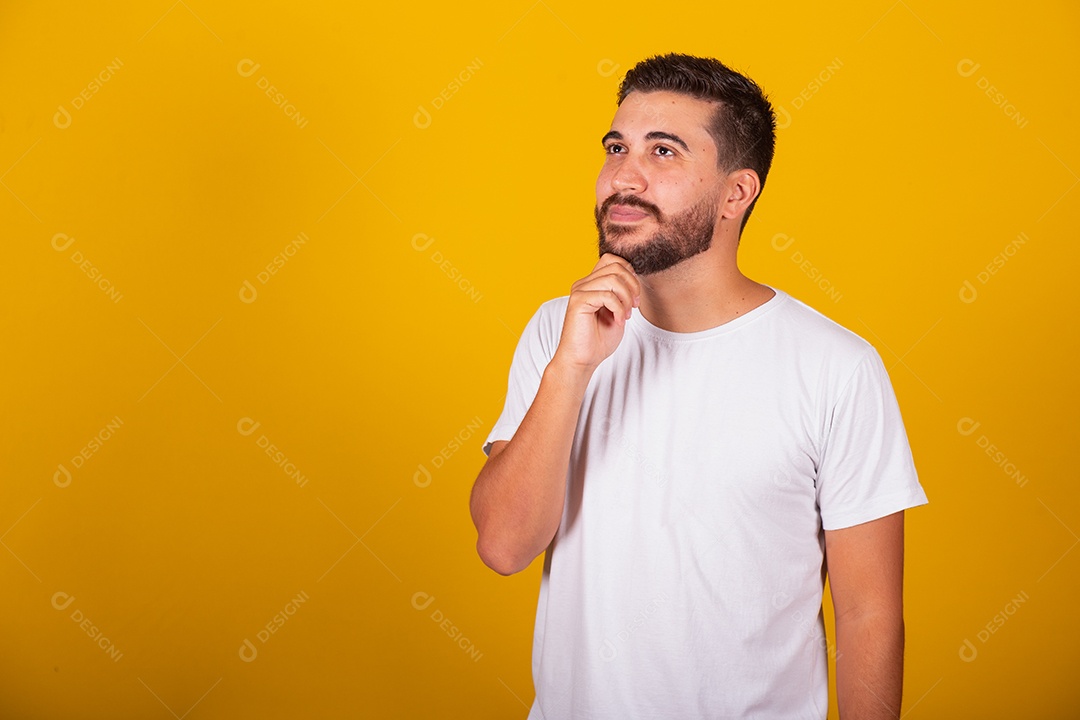 Homem jovem brasileiro usando camiseta branca fundo amarelo