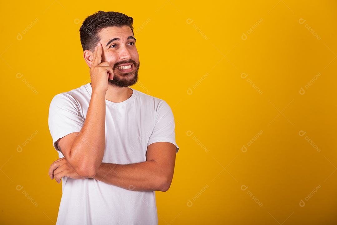 Homem jovem brasileiro usando camiseta branca fundo amarelo