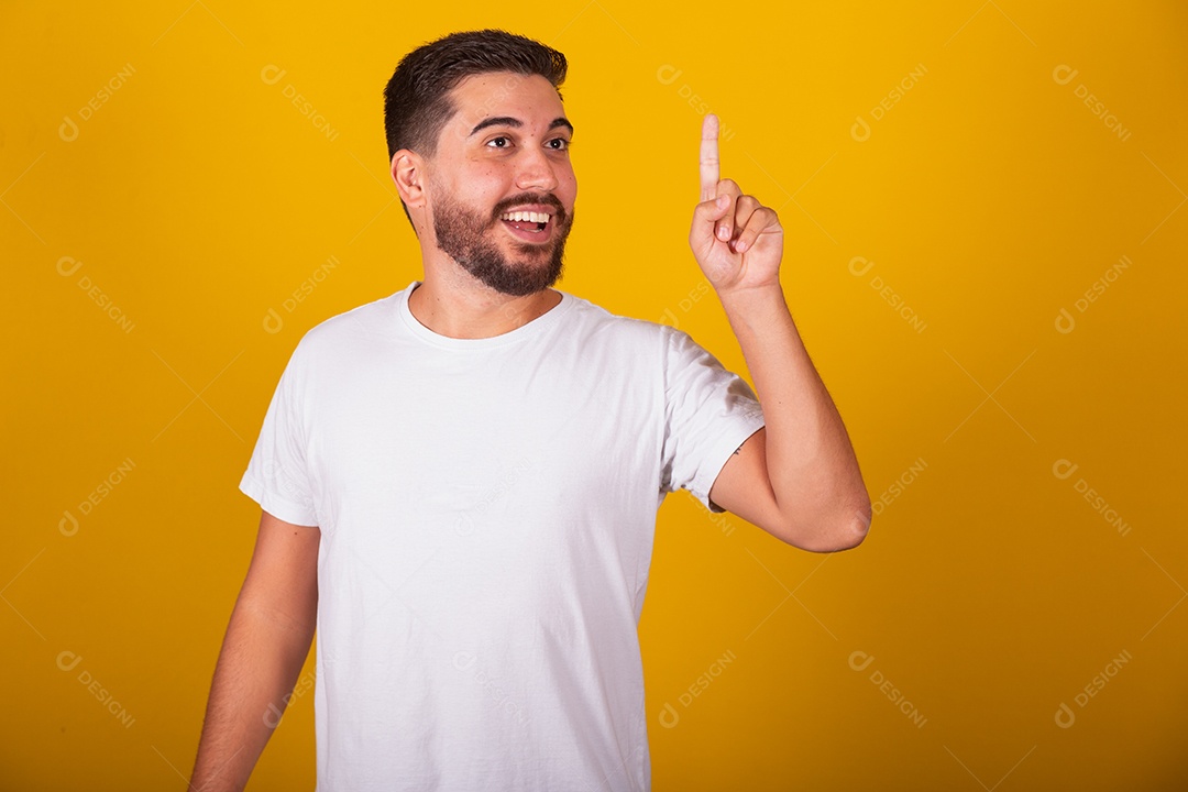 Homem jovem brasileiro usando camiseta branca fundo amarelo