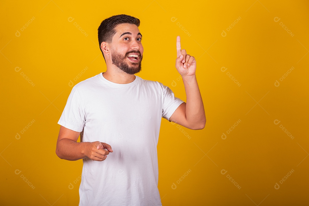 Homem jovem brasileiro usando camiseta branca fundo amarelo