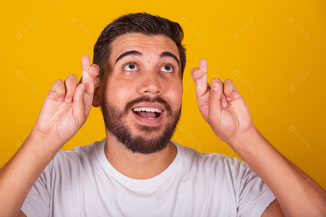 Homem jovem brasileiro usando camiseta branca fundo amarelo