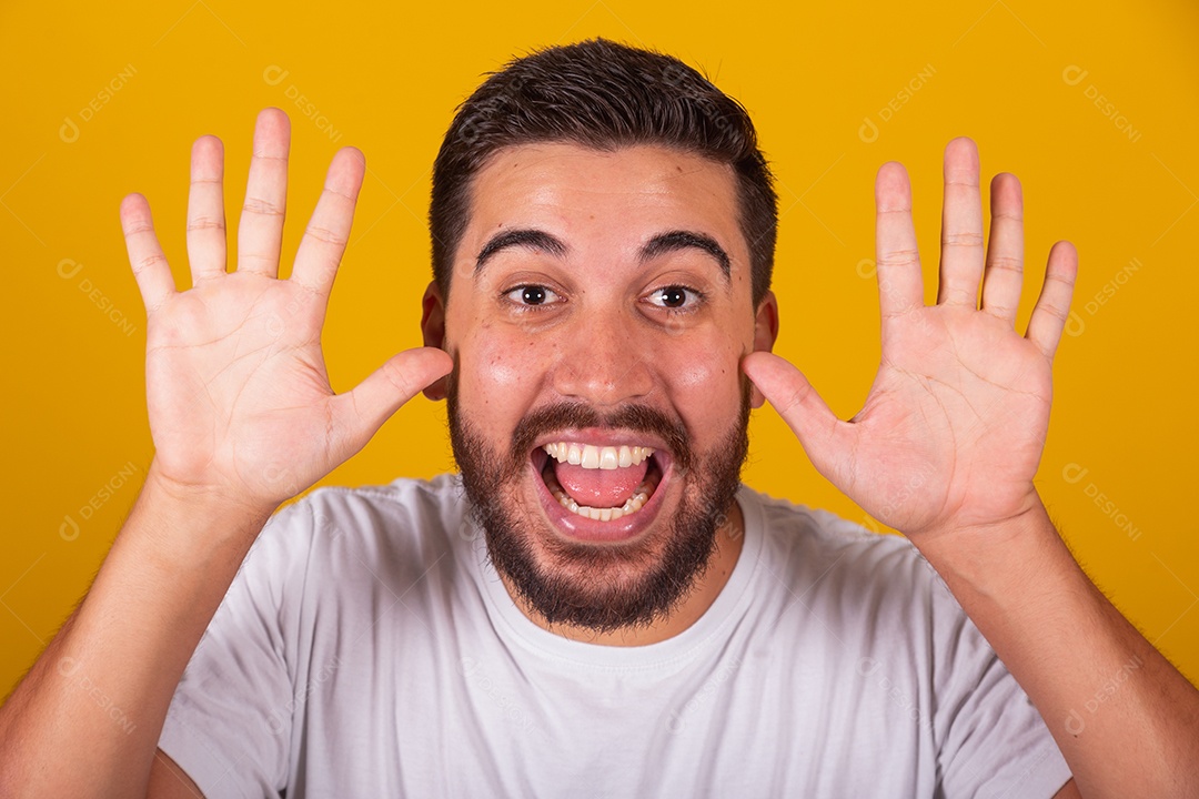 Homem jovem brasileiro usando camiseta branca fundo amarelo