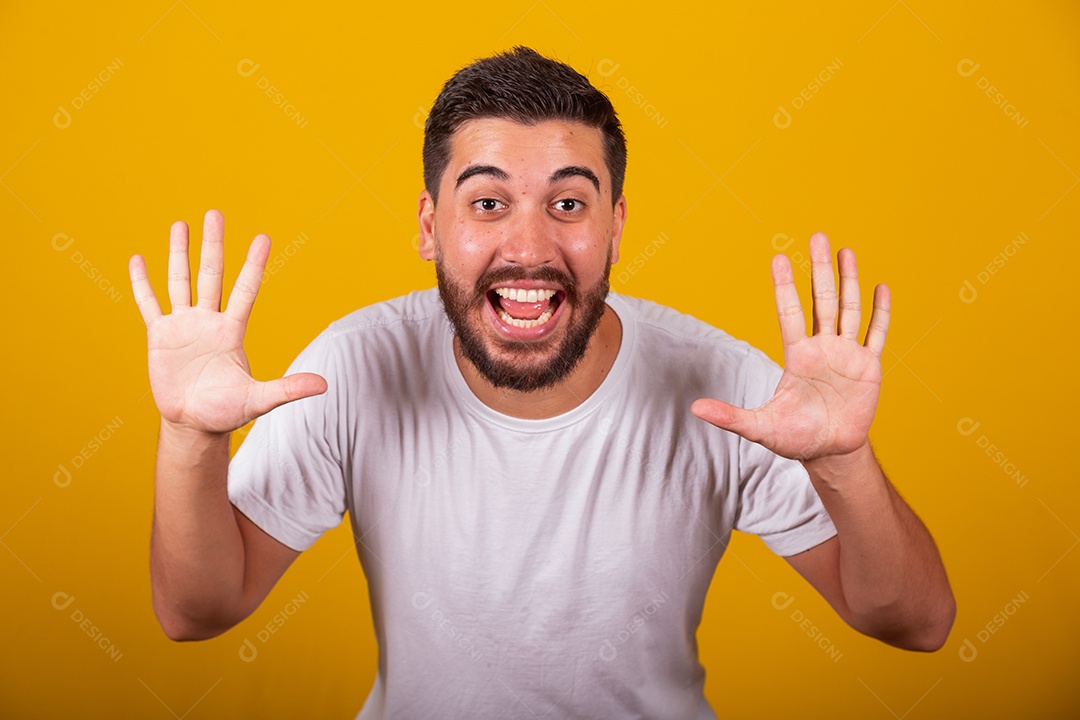 Homem jovem brasileiro usando camiseta branca fundo amarelo