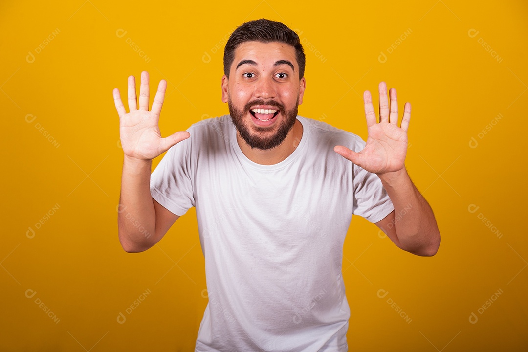 Homem jovem brasileiro usando camiseta branca fundo amarelo