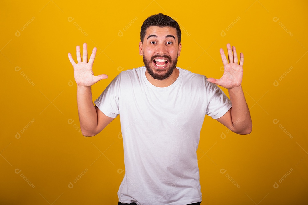 Homem jovem brasileiro usando camiseta branca fundo amarelo