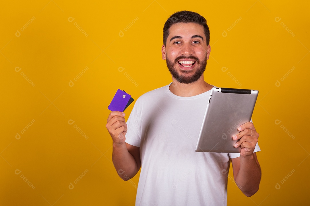 Homem jovem segurando segurando celular e fazendo compras no cartão