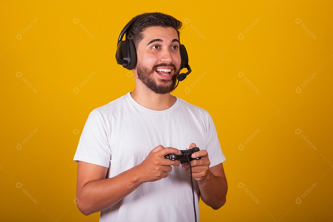 Homem jovem brasileiro feliz com fone de ouvido e controlador de videogame jogando