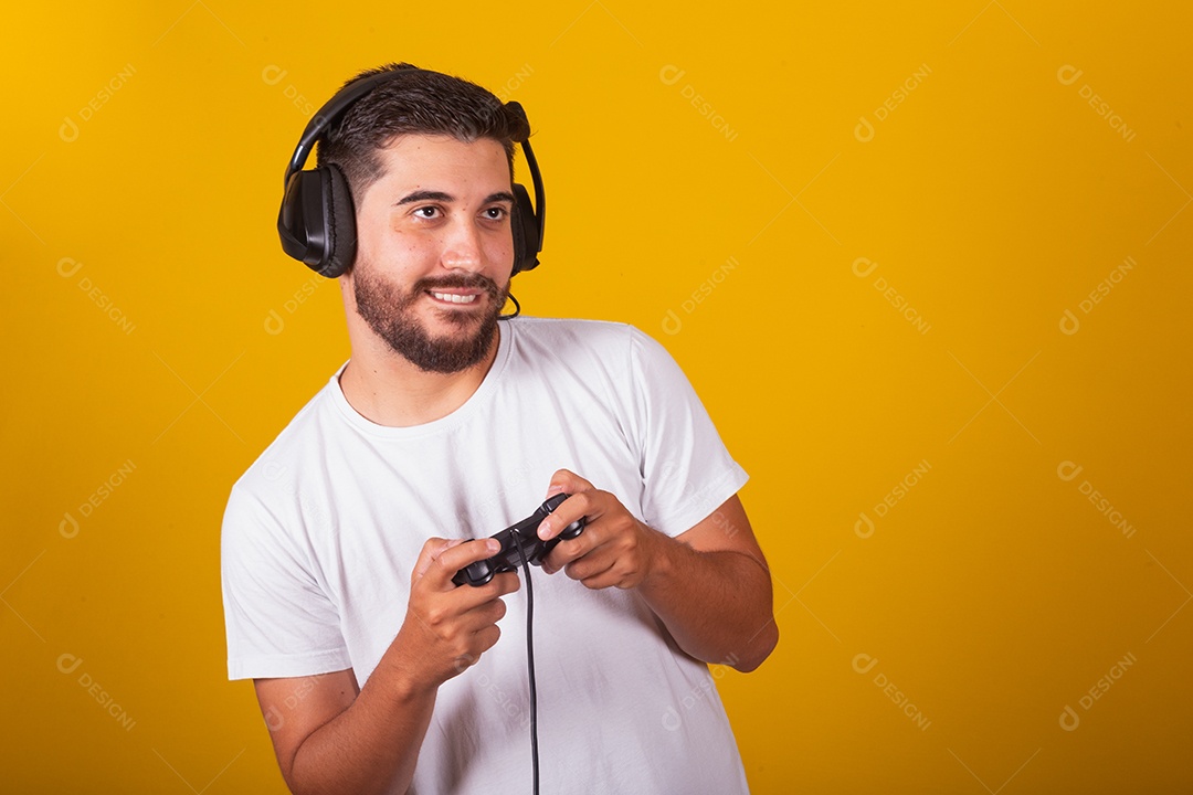 Homem jovem brasileiro feliz com fone de ouvido e controlador de videogame jogando