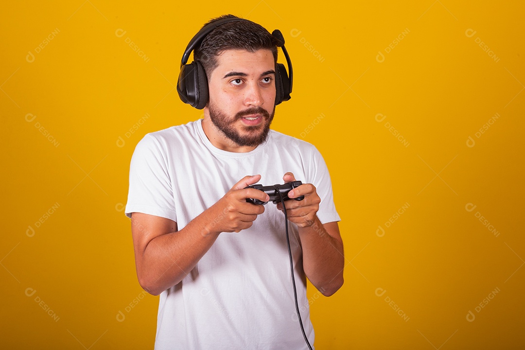 Homem jovem brasileiro feliz com fone de ouvido e controlador de videogame jogando