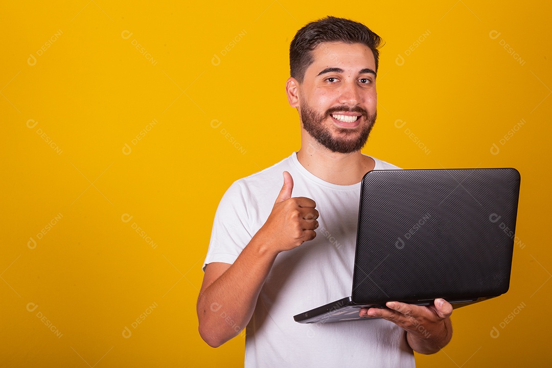 Homem latino-americano brasileiro, feliz, segurando notebook e sorrindo