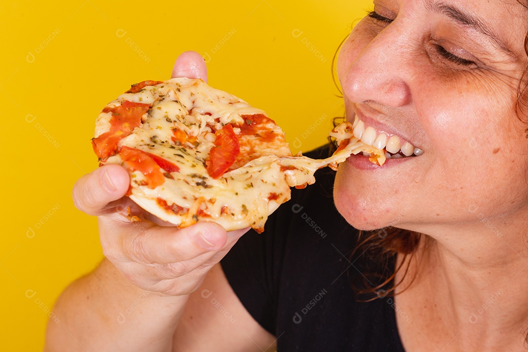 Linda mulher jovem garota segurando mini pizza sobre fundo isolado amarelo