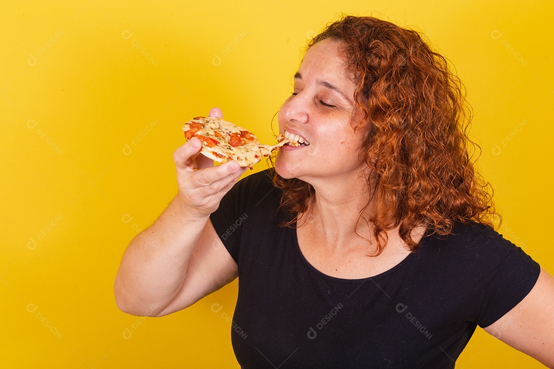 Linda mulher jovem garota segurando mini pizza sobre fundo isolado amarelo