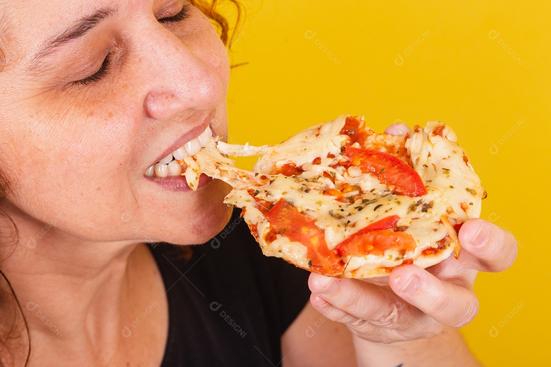 Linda mulher jovem garota segurando mini pizza sobre fundo isolado amarelo