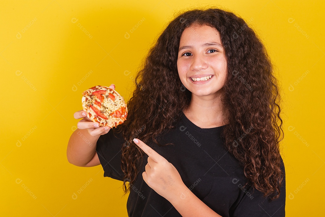 Linda mulher jovem garota segurando mini pizza sobre fundo isolado amarelo