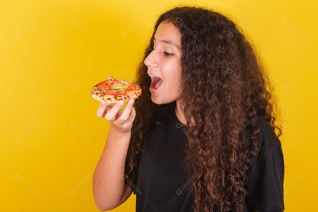 Beautiful woman young girl holding mini pizza over isolated yellow background