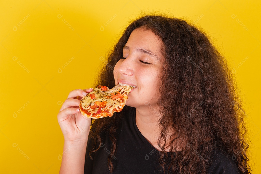 Linda mulher jovem garota segurando mini pizza sobre fundo isolado amarelo