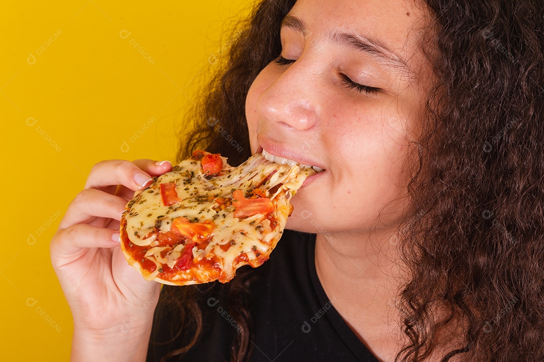 Linda mulher jovem garota segurando mini pizza sobre fundo isolado amarelo