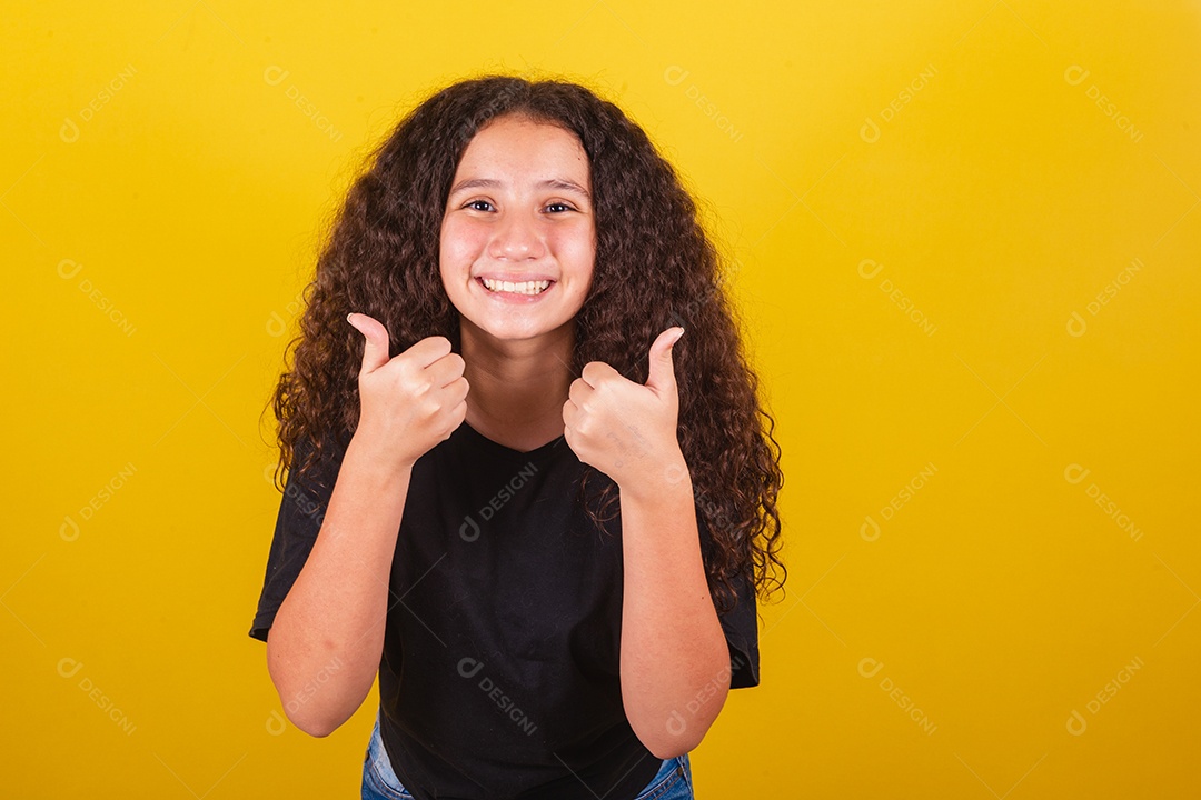 Linda mulher cabelo cacheado jovem sobre fundo isolado amarelo