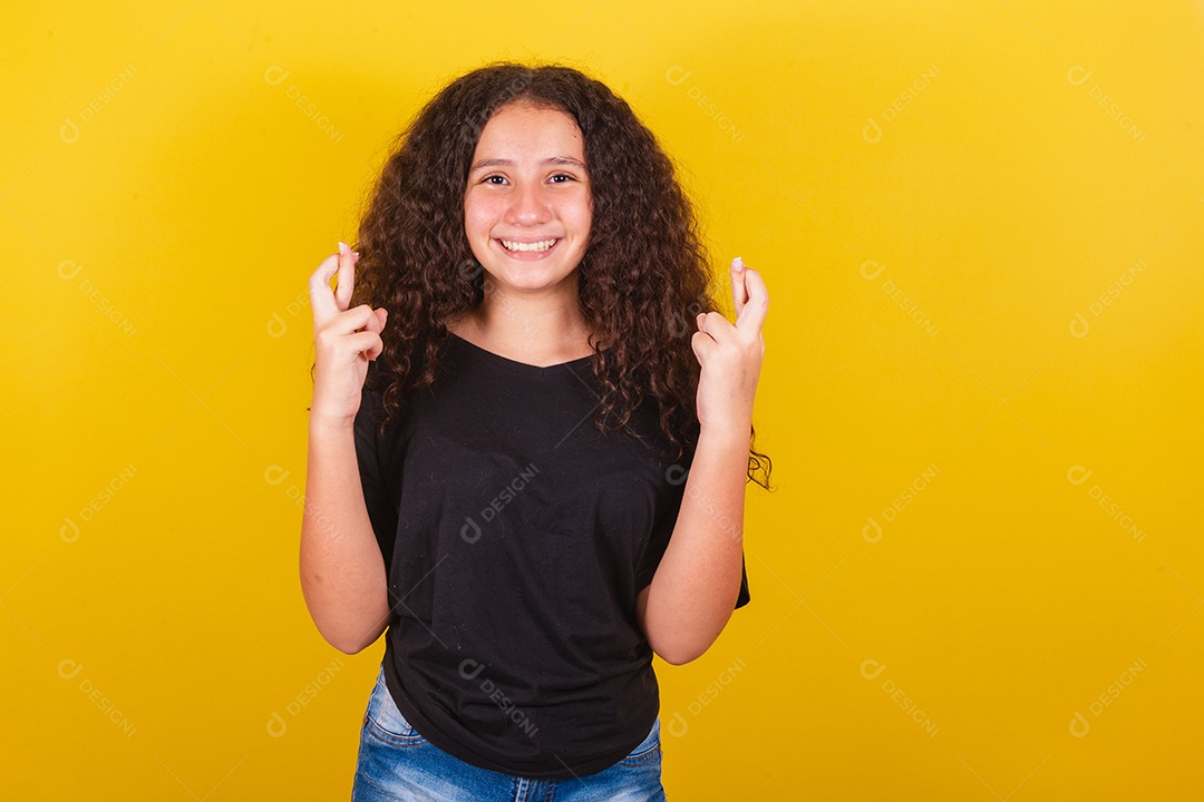 Linda mulher cabelo cacheado jovem sobre fundo isolado amarelo