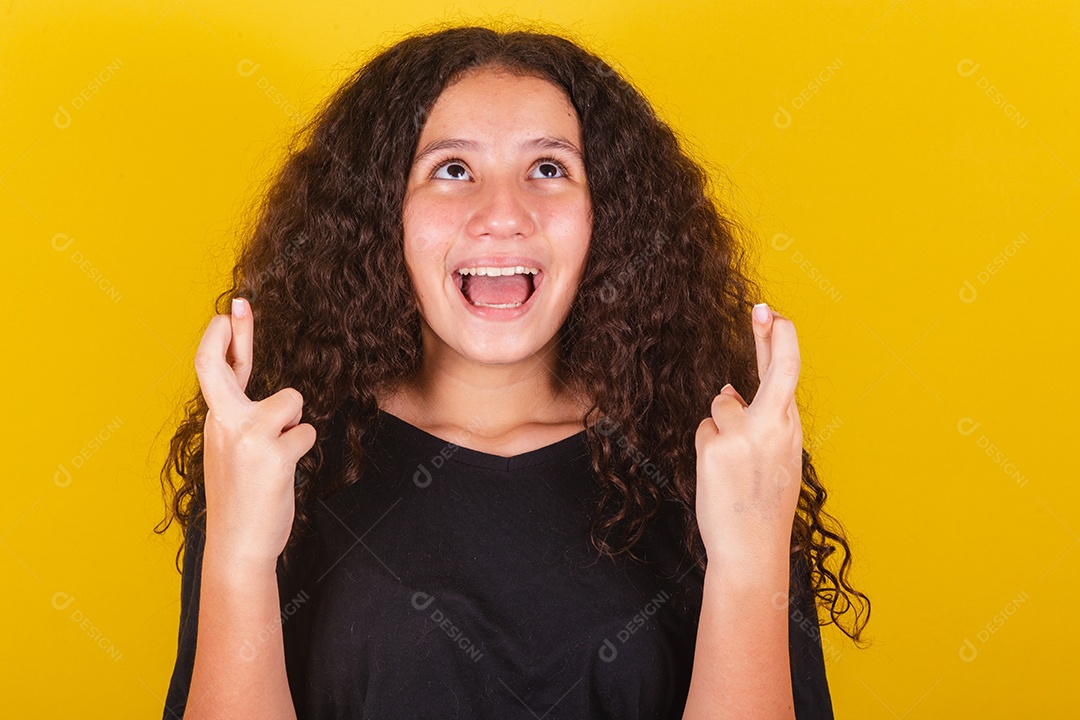 Linda mulher cabelo cacheado jovem sobre fundo isolado amarelo