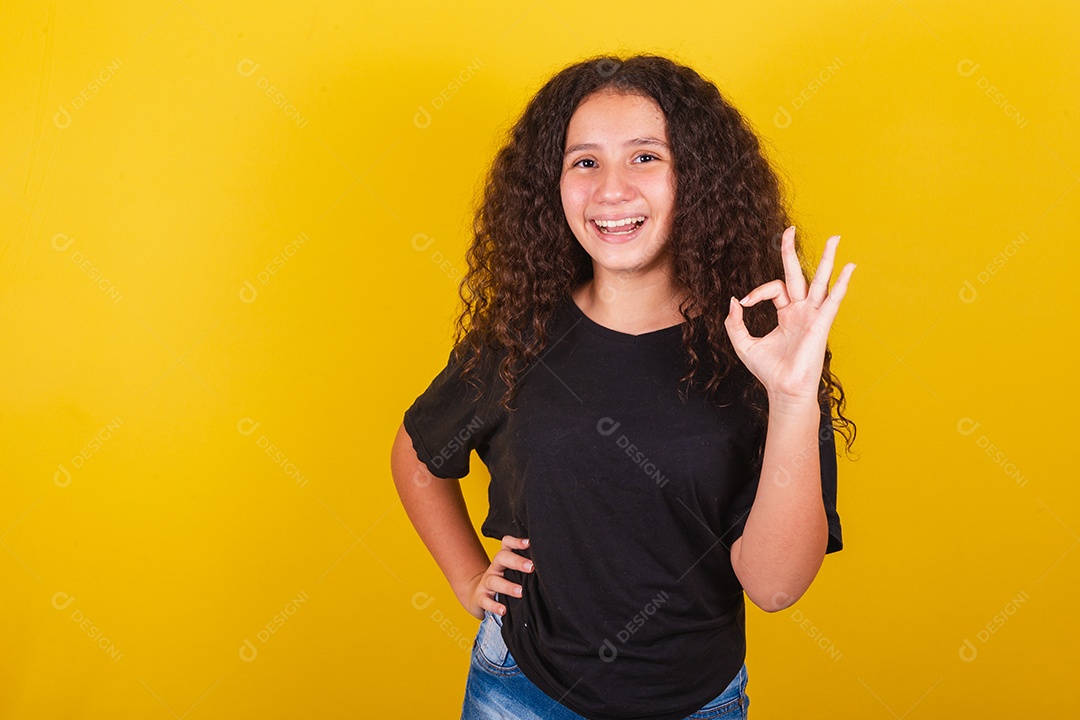 Linda mulher cabelo cacheado jovem sobre fundo isolado amarelo
