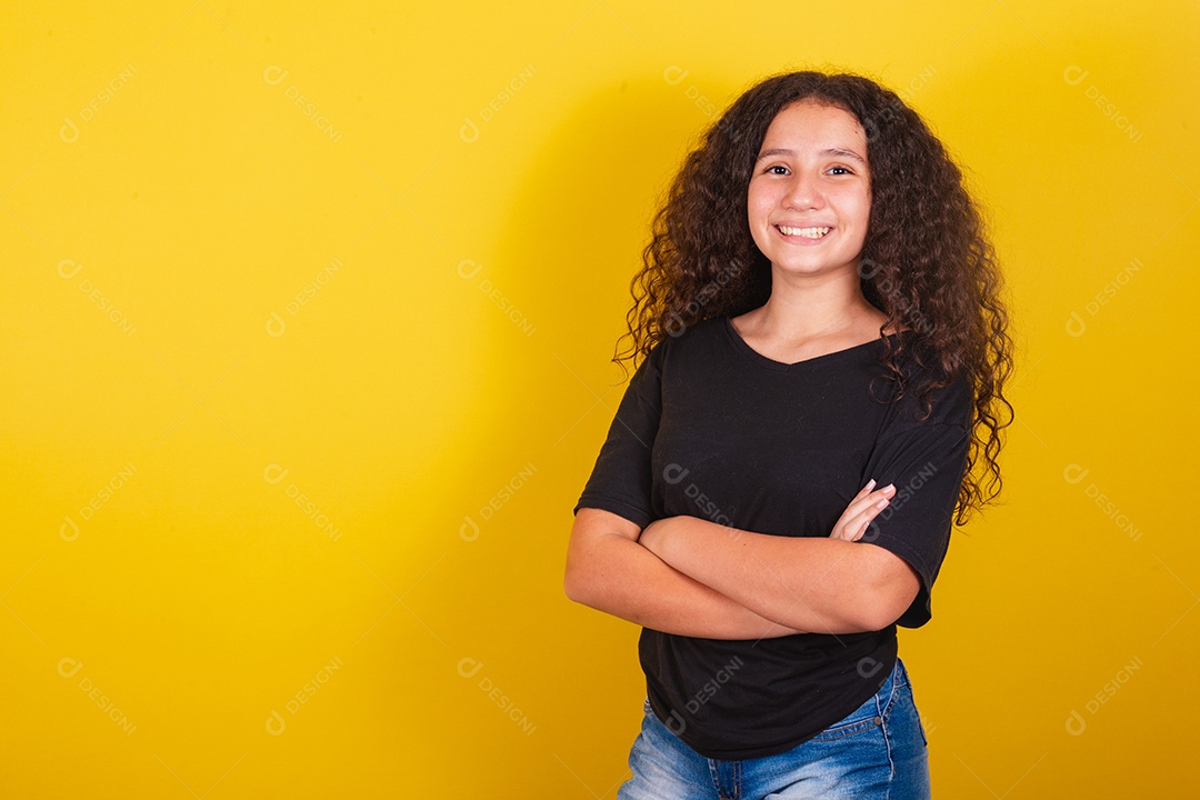 Linda mulher cabelo cacheado jovem sobre fundo isolado amarelo