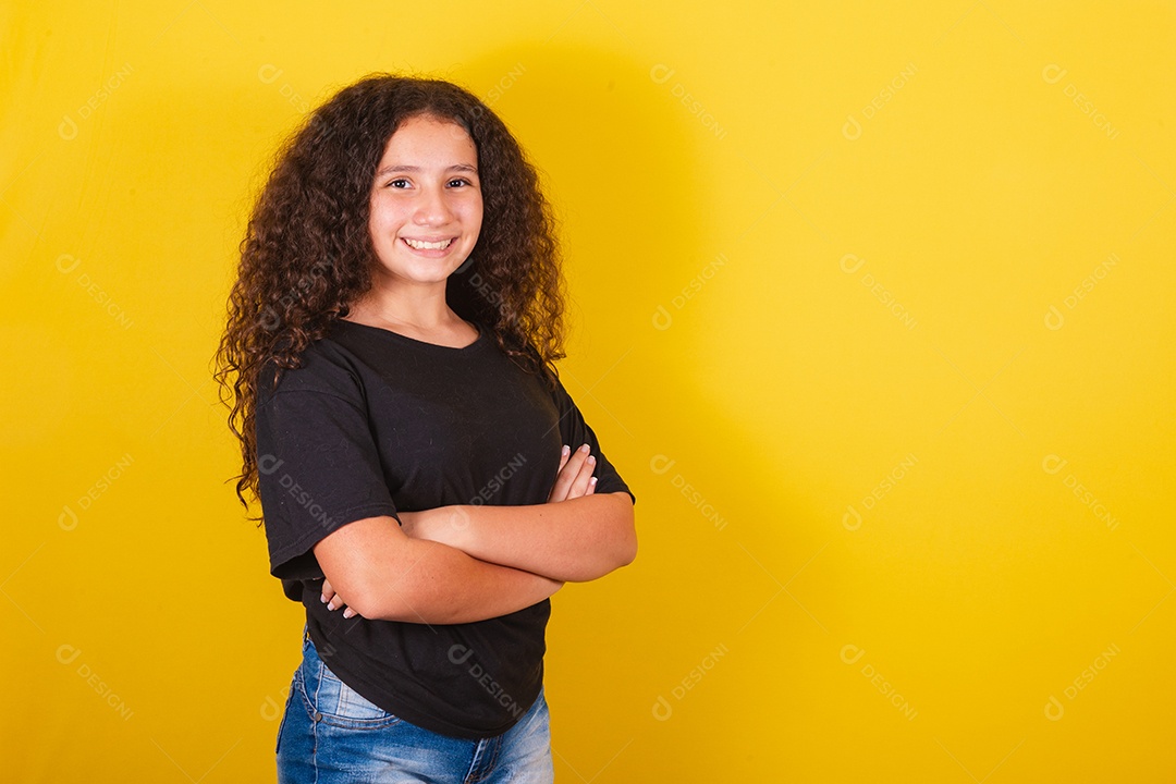 Linda mulher cabelo cacheado jovem sobre fundo isolado amarelo