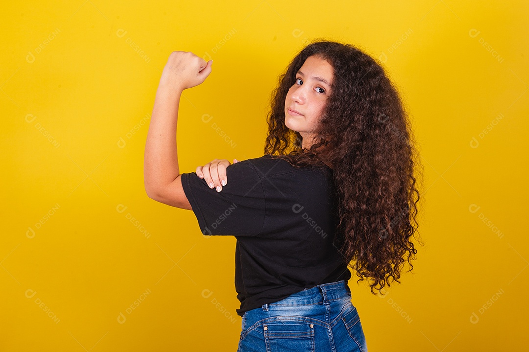 Linda mulher cabelo cacheado jovem sobre fundo isolado amarelo